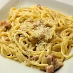 Pyszne spaghetti carbonara z kawałkami boczku i parmezanem. Idealna śmietana do carbonary to sekret kremowego sosu.