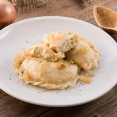 Pyszne pierogi ruskie na talerzu, posypane pieprzem. Zastanawiasz się nad pierogi ruskie kcal? Idealne na obiad!