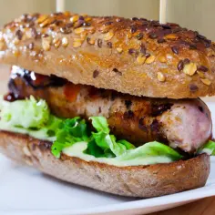 Pyszne, domowe hot dogi z bułką pełnoziarnistą, soczystą kiełbaską, chrupiącą sałatą i sosami.