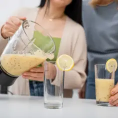 Kobieta nalewa smoothie do szklanki. To pyszny napój, który może pomóc w odchudzaniu, jeśli wybierzesz odpowiedni błonnik.