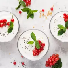Trzy miseczki jogurtu naturalnego z porzeczkami i miętą. Idealny, lekki deser, który nie obciąży Twojej diety, jeśli zwracasz uwagę na jogurt naturalny kcal.