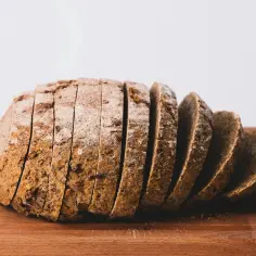 Pokrojony chleb żytni na drewnianej desce. Idealny na zdrowe śniadanie, z niską zawartością kcal.