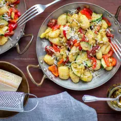 Pyszne gnocchi z pesto, posypane parmezanem i udekorowane listkami bazylii. Widok, który pobudza apetyt!