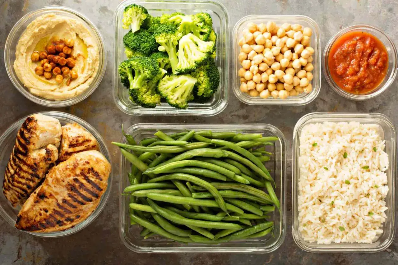 Przygotowane posiłki: grillowany kurczak, hummus, brokuły, fasolka szparagowa, ciecierzyca, ryż i sos. Idealne do meal prep i okno żywieniowe.