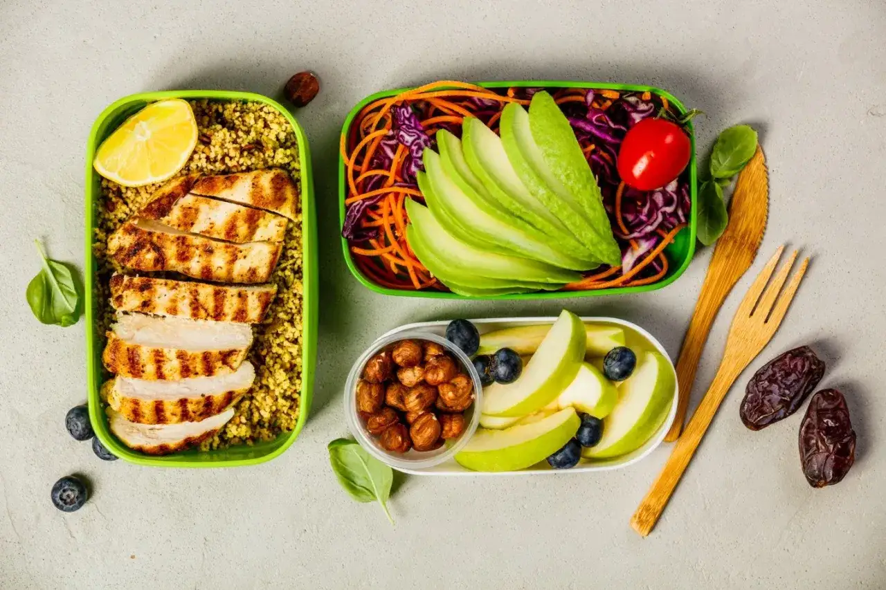 Pyszne posiłki na keto dietę: grillowany kurczak z kaszą, sałatka z awokado i warzywami, jabłka z borówkami i orzechy.