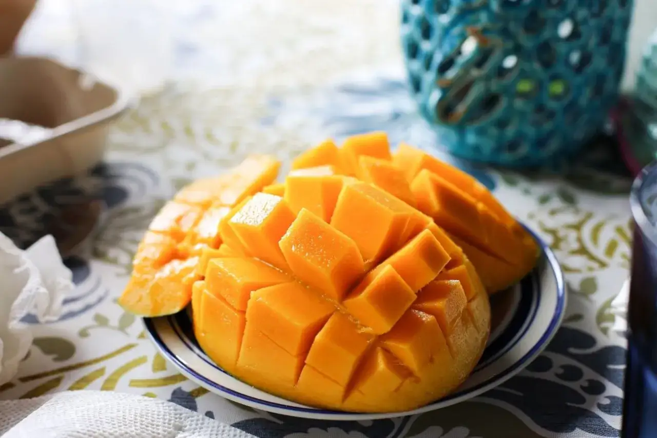 Soczyste, pokrojone w kostkę mango na talerzyku. Idealna przekąska, gdy zastanawiasz się nad mango kcal.