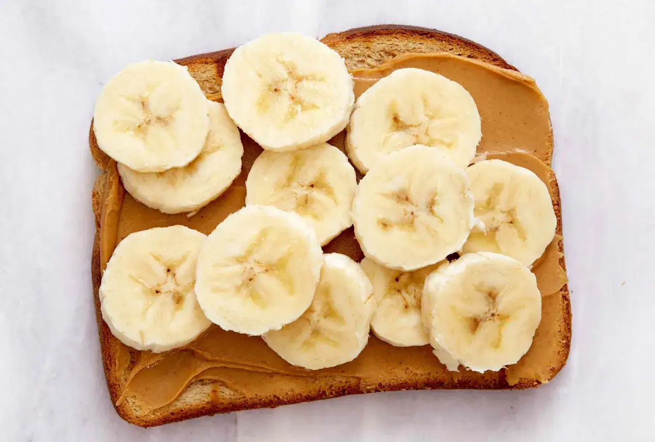 Chleb tostowy z masłem orzechowym i plasterkami banana. Idealny banan na noc dla małych i dużych łasuchów.
